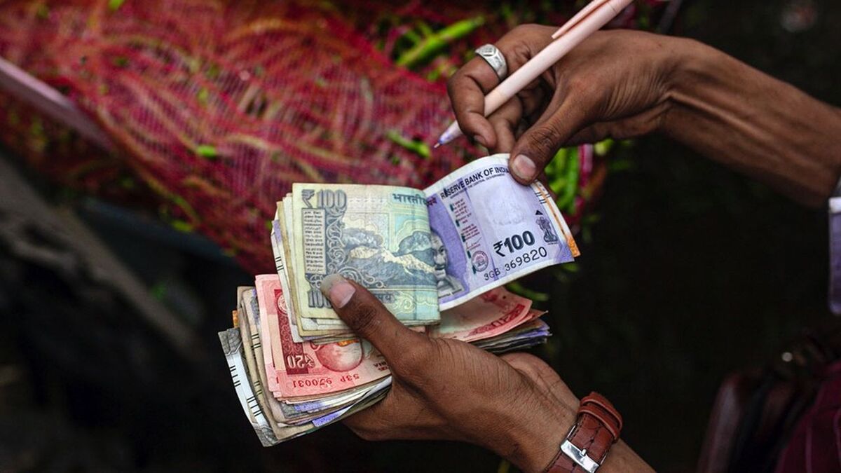 A vegetable vendor counts rupee banknotes at wholesale market in Ahmedabad, India, on Wednesday, July 19, 2023. A spike in inflation in June justifies the decision of Indian policymakers to maintain higher rates for longer, the country's central bank said in a report. Photographer: Dhiraj Signh/Bloomberg